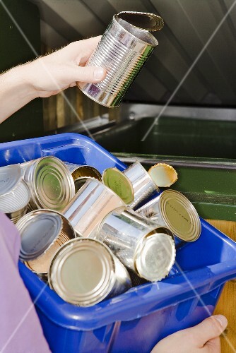Person wirft Dose in Müllcontainer