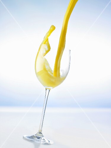 Pouring orange juice into a glass (splash)