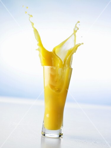 Pouring orange juice into a glass (splash)