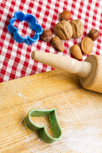 Rolling pin, biscuit cutters and nuts with wooden board