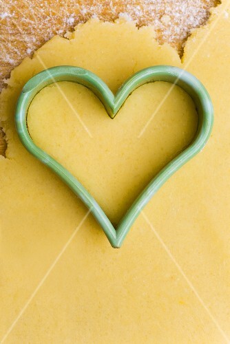 Heart-shaped cutter on biscuit dough