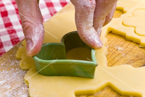 Cutting out a biscuit with a heart-shaped cutter