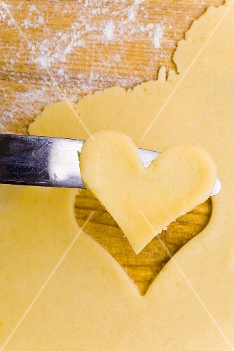 Cut-out heart-shaped biscuit on knife