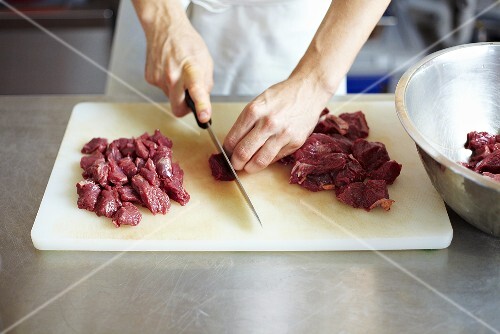 Koch schneidet Rindfleisch