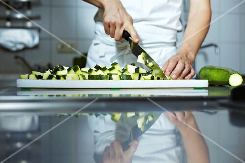 Koch schneidet Zucchini