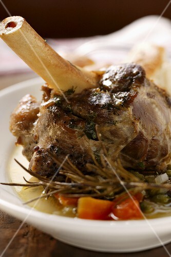 Braised lamb shank with vegetables & rosemary on plate