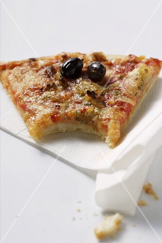 Angebissenes Stück Pizza mit Thunfisch und Oliven