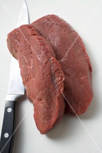 Zwei Scheiben Rinderlende mit Messer