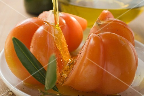 Pouring olive oil over tomatoes