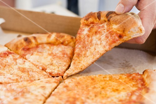 Hand taking piece of Pizza Margherita out of pizza box