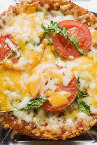 Mini-pizza with tomato, cheese and rocket