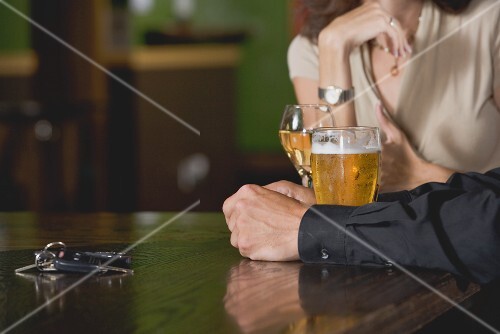 Mann und Frau mit Bier und Wein an der Bar; Autoschlüssel
