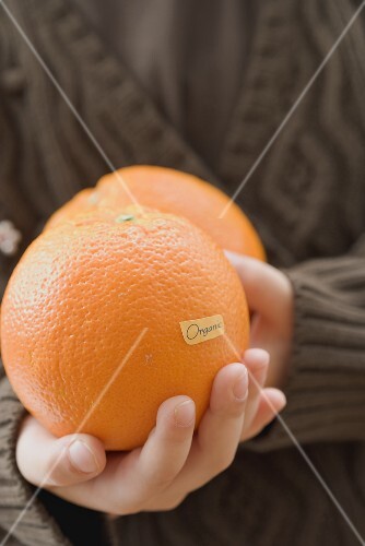 Girl holding organic oranges