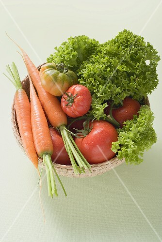 Körbchen mit frischen Tomaten, Karotten und Salat