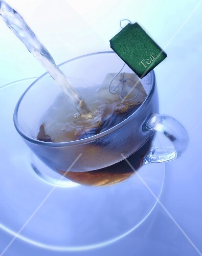 Pouring boiling water onto tea bag