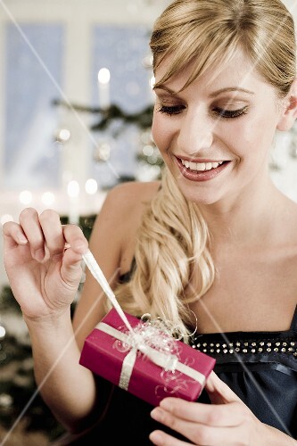 Woman unwrapping Christmas gift