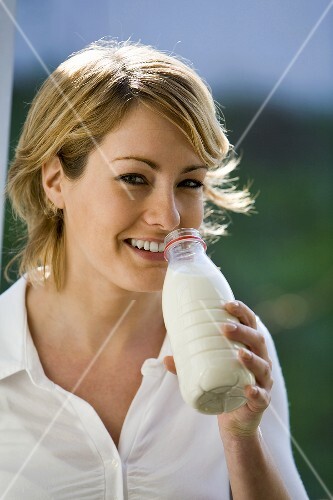 Young woman drinking milk out of a bottle