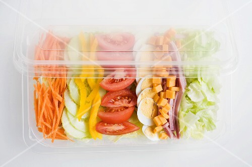 Mixed salad with ham and egg in a plastic tray