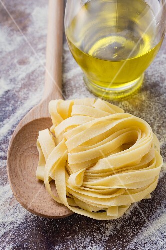 Selbstgemachte Bandnudeln mit Kochlöffel und Olivenöl