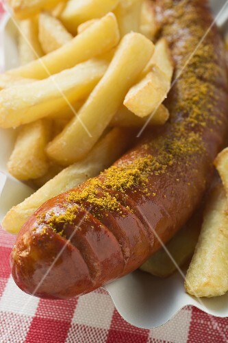Currywurst with chips in a paper dish