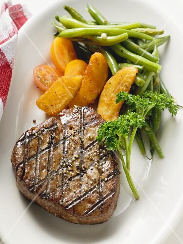 Grilled fillet steak with country potatoes and bean salad