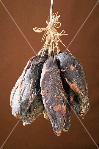 Smoked venison ham on a hook