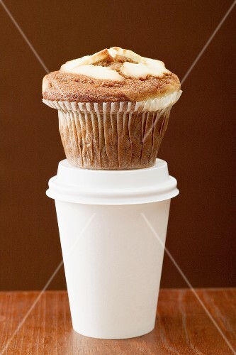 A muffin on a plastic coffee cup