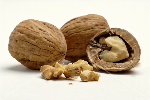 Two unshelled walnuts and one opened walnut