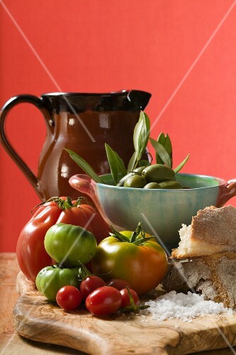 Fresh tomatoes, olives, bread, salt and terracotta jug