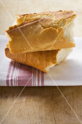 Two pieces of baguette on tea towel