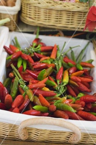 Fresh chili peppers in a basket at a market