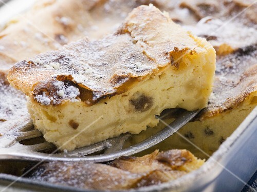 Curd cheese strudel in baking tin with piece on server