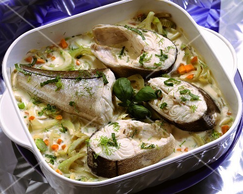 Cod pieces in a baking pan with vegetables & cream