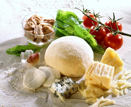 Ingredients for pizza: pizza dough, cheese, tuna, tomatoes