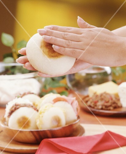 Hands holding corn rolls (Arepa), Venezuela