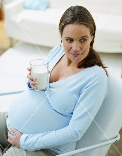 Pregnant woman drinking glass of milk