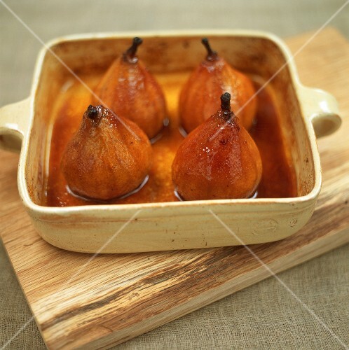 Four baked pears with honey in baking dish