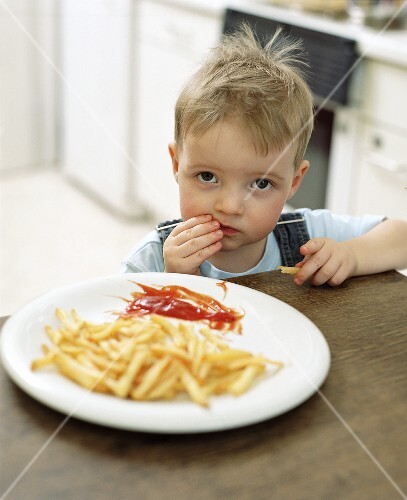 Small boy eating chips