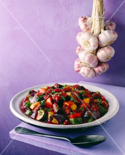 Ratatouille on plate in front of garlic rope