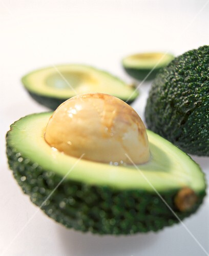 Avocado halves, one with stone