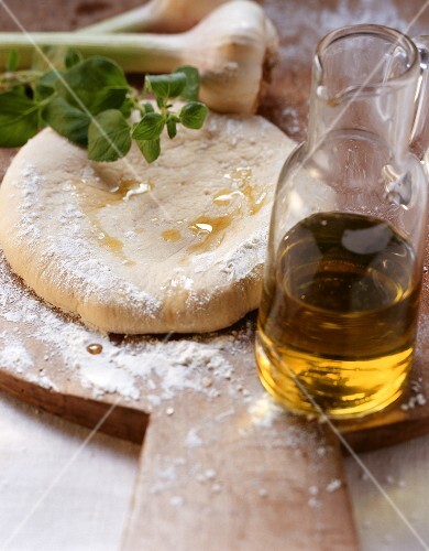 Unbaked pizza, herbs, garlic and olive oil