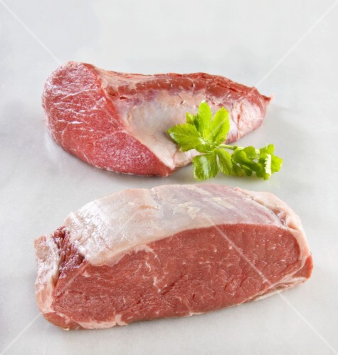 Zwei Stücke frisches Rindfleisch auf Marmoruntergrund