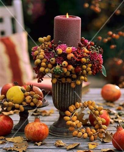 Eine brennende Kerze auf einem herbstlich dekorierten Tisch