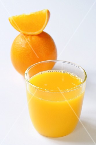 Glass of orange juice, orange and orange wedge
