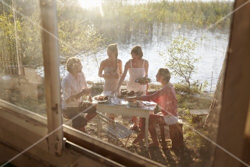 Young people eating by a lake