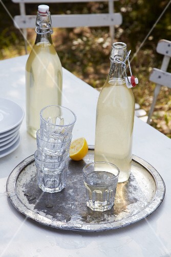 Two bottles of lemonade and glasses on a tray