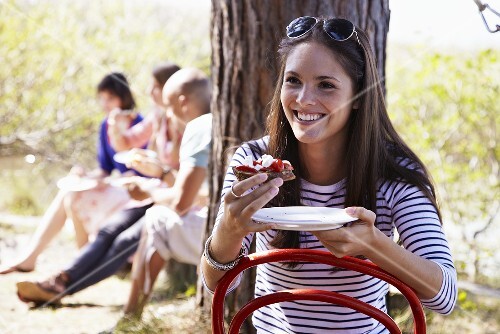 Young woman eating tomato and goat cheese crostini