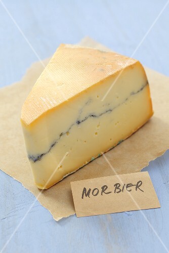 Piece of Morbier cheese on paper