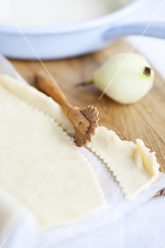 Still life with peeled pear and rolled-out pastry
