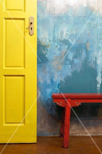 A patchy blue wall with yellow door